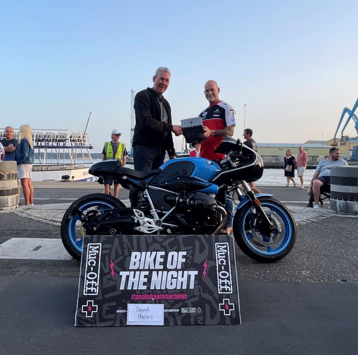 Men shake hands next to bike at Poole quay